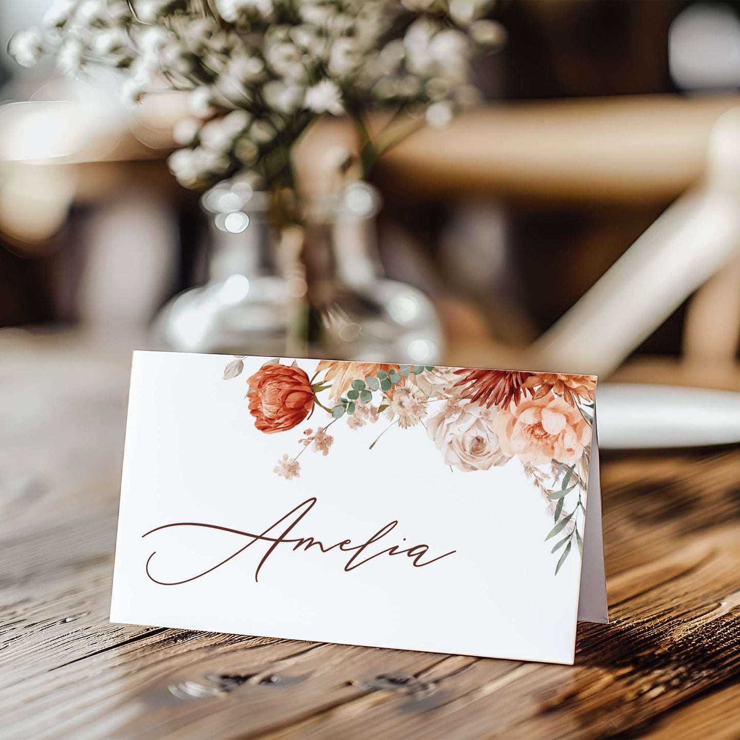 a table with a place card and a vase of flowers