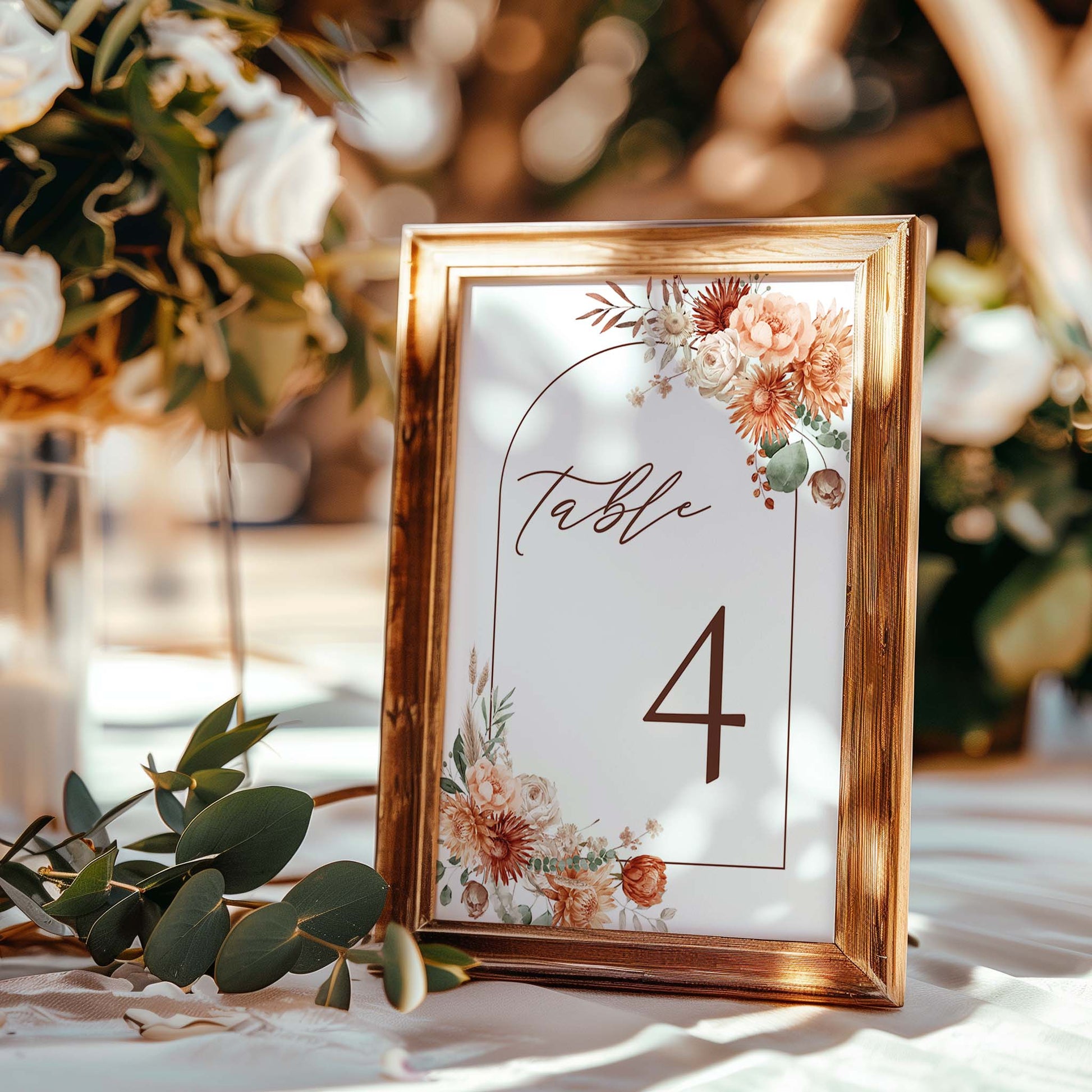 a table number with flowers and greenery on it