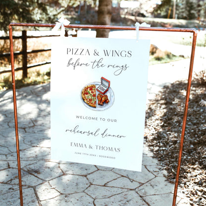 Pizza and Wings Before the Rings rehearsal dinner welcome sign featuring watercolor pizza, chicken wings, and an engagement ring box with elegant black typography on white.