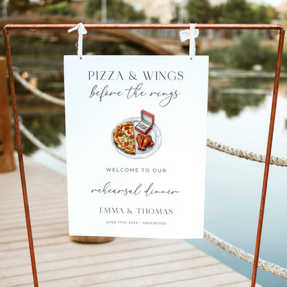 Pizza and Wings Before the Rings rehearsal dinner welcome sign featuring watercolor pizza, chicken wings, and an engagement ring box with elegant black typography on white.