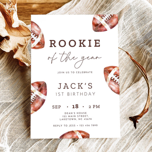 Rookie of the Year football first birthday invitation featuring vintage watercolor brown footballs, elegant script typography, and personalized birthday party details on a white background.