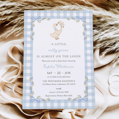 A baby shower invitation card featuring a light blue and white gingham border, a cute duck illustration, and elegant typography.