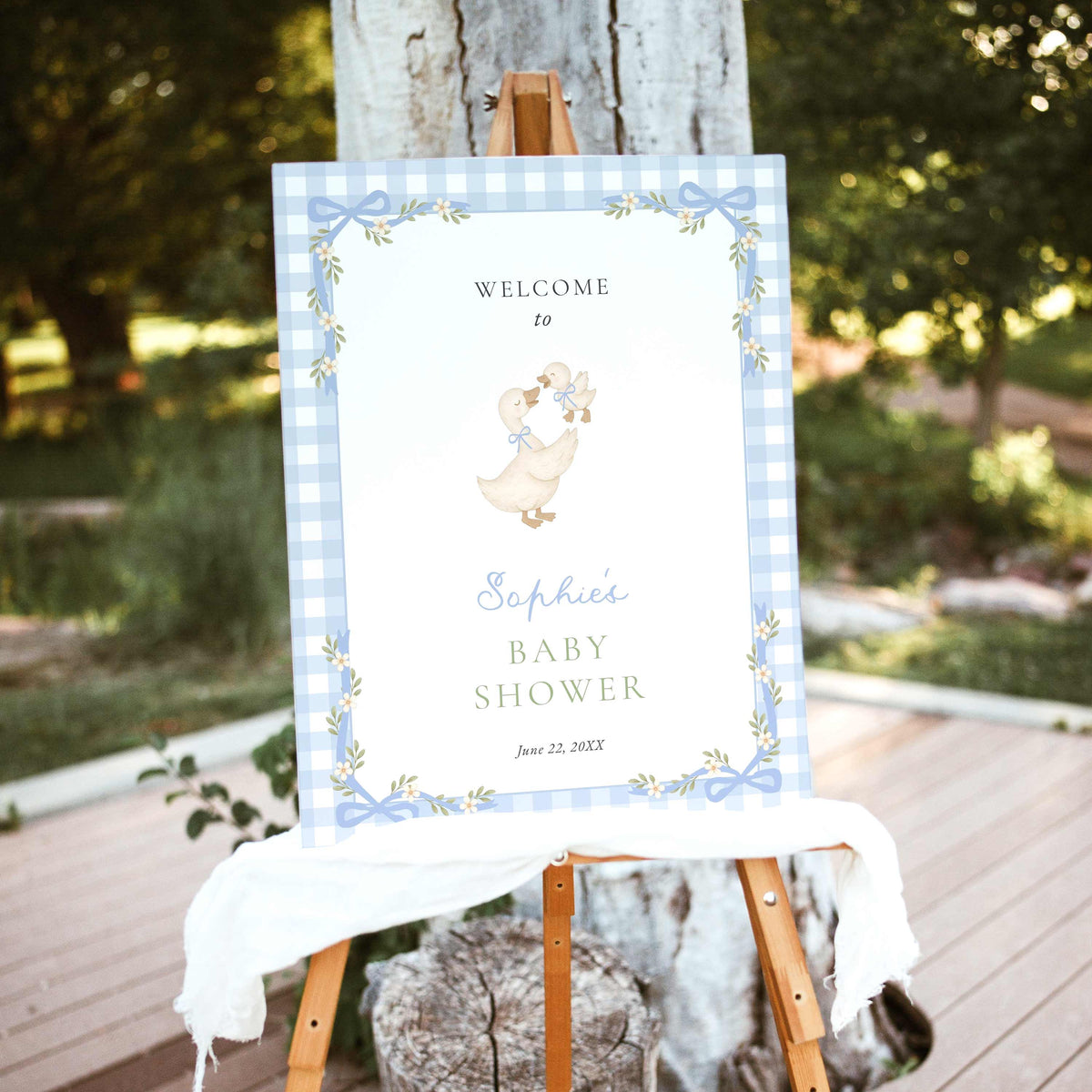 Blue gingham silly goose baby shower welcome sign featuring watercolor mother goose and gosling, pastel blue bows, white daisies, and a delicate floral ribbon border.